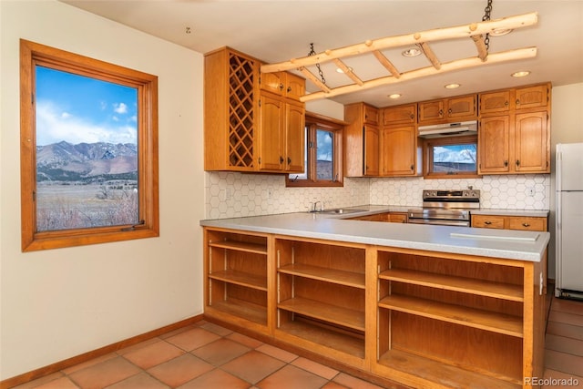 kitchen featuring stainless steel electric range oven, open shelves, tasteful backsplash, and freestanding refrigerator