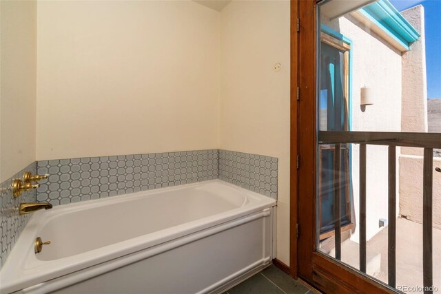 full bath featuring a healthy amount of sunlight, a garden tub, and tile patterned floors