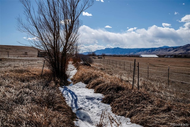 view of yard with fence, a mountain view, and a rural view