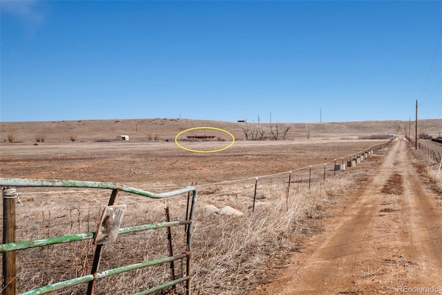 view of yard with a rural view and fence