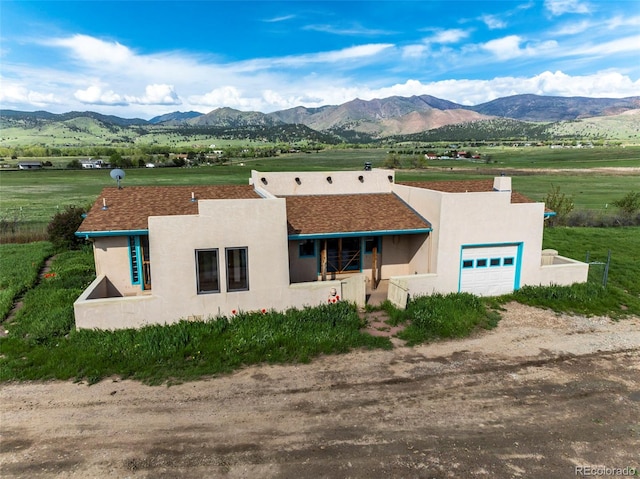 8602 N 39th St, Longmont, CO 80503 - view of front facade featuring an attached garage, a mountain view, stucco siding, and a rural view