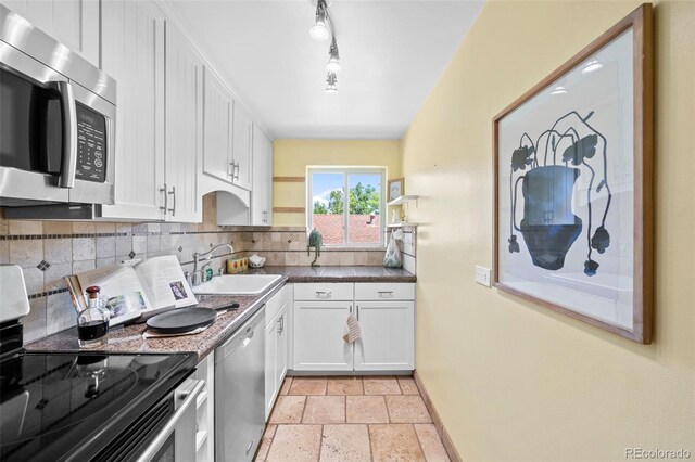 2047 S Milwaukee St Unit 4, Denver, CO 80210 - kitchen with a sink, stone tile floors, stainless steel appliances, white cabinetry, and decorative backsplash