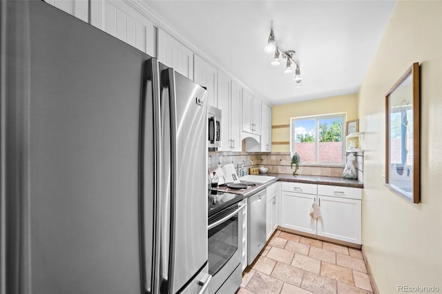 2047 S Milwaukee St Unit 4, Denver, CO 80210 - kitchen with stone tile flooring, decorative backsplash, dark countertops, white cabinets, and appliances with stainless steel finishes