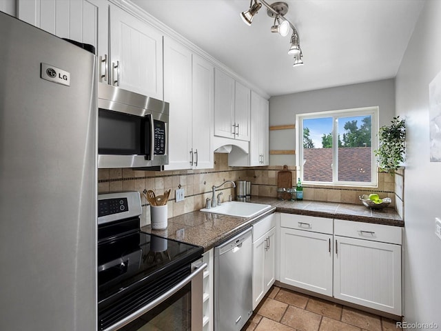 2047 S Milwaukee St Unit 4, Denver, CO 80210 - kitchen with appliances with stainless steel finishes, white cabinetry, backsplash, stone tile flooring, and tile countertops
