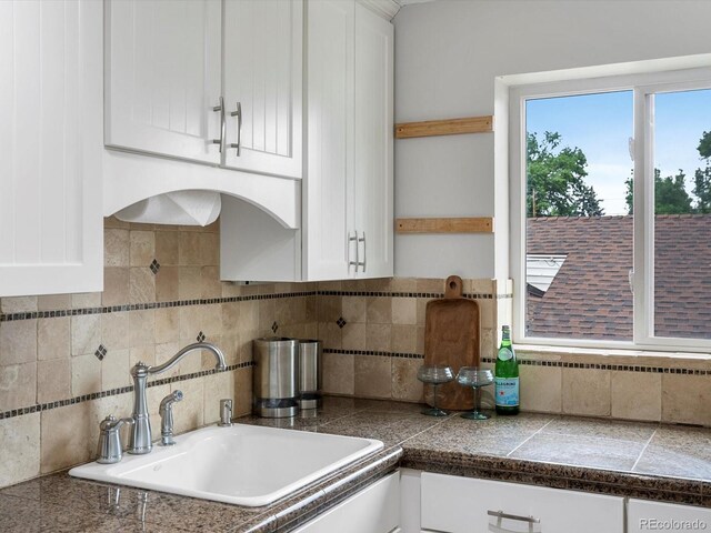2047 S Milwaukee St Unit 4, Denver, CO 80210 - kitchen with tile counters, white cabinets, and decorative backsplash