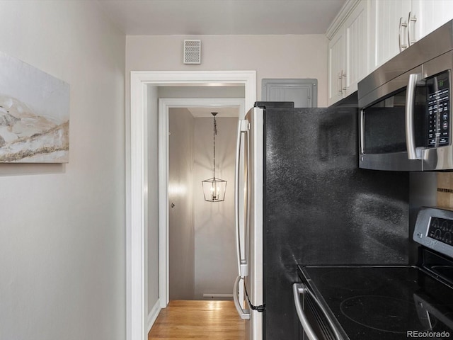 2047 S Milwaukee St Unit 4, Denver, CO 80210 - kitchen featuring appliances with stainless steel finishes, white cabinetry, and light wood-style floors
