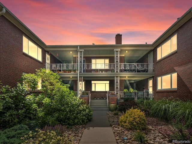 2047 S Milwaukee St Unit 4, Denver, CO 80210 - view of front of property with a balcony, a porch, a chimney, and brick siding