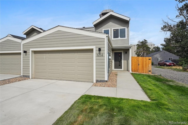 view of property with a garage and a front lawn