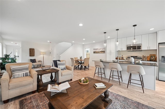 living room with light wood-type flooring and sink