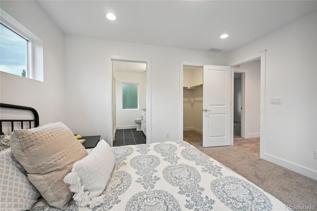 carpeted bedroom with a spacious closet, a closet, and connected bathroom