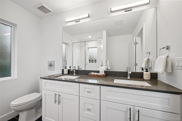 bathroom with toilet, vanity, and an enclosed shower