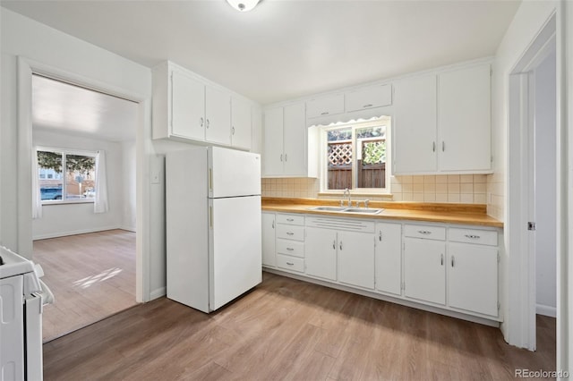 kitchen featuring white appliances, sink, and white cabinets