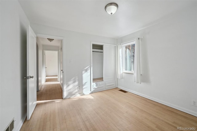 unfurnished bedroom featuring light hardwood / wood-style flooring and a closet