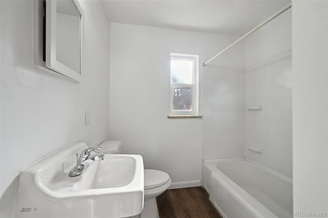 full bathroom with sink, hardwood / wood-style flooring,  shower combination, and toilet