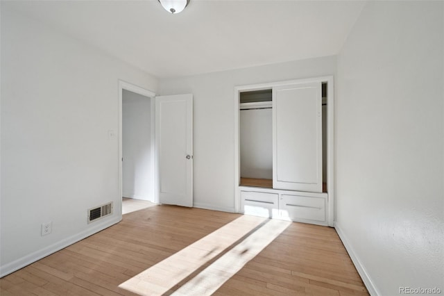 unfurnished bedroom featuring light hardwood / wood-style floors and a closet