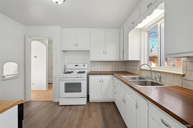 kitchen featuring white cabinetry, sink, white gas stove, and hardwood / wood-style floors