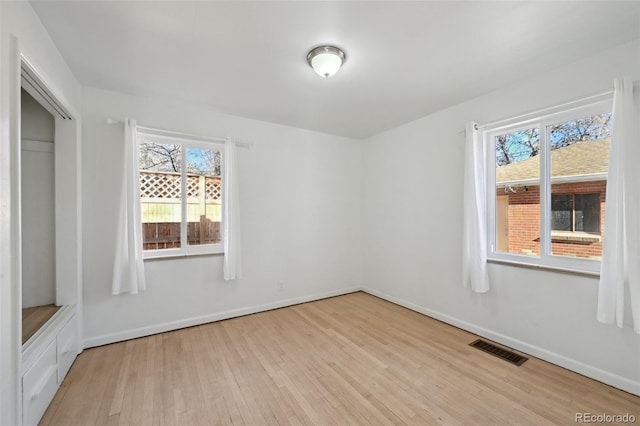 unfurnished room with plenty of natural light and light hardwood / wood-style floors