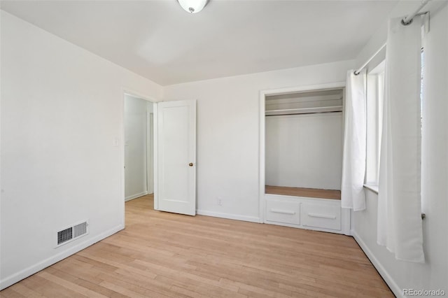 unfurnished bedroom featuring a closet and light wood-type flooring