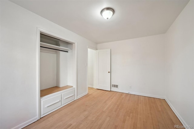 unfurnished bedroom with a closet and light wood-type flooring