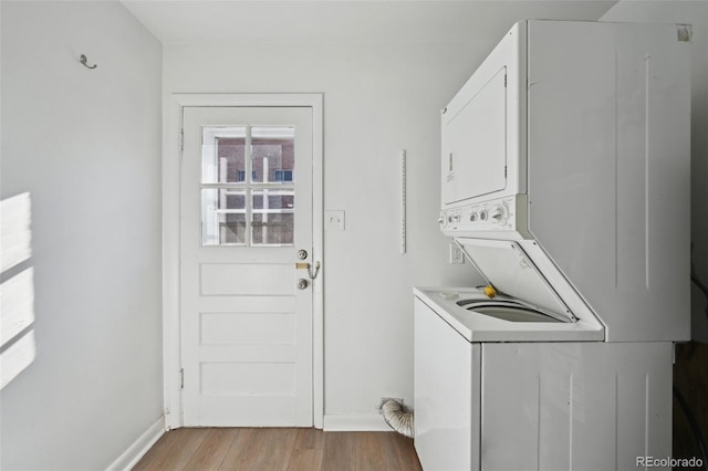 washroom featuring stacked washer and dryer and light wood-type flooring