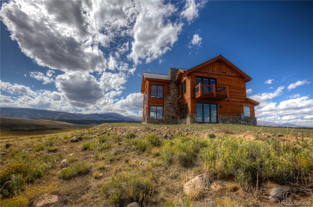 rear view of house with a rural view and a mountain view