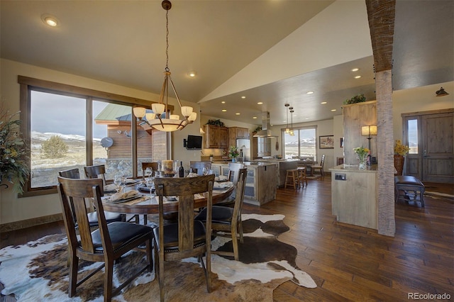 dining space with high vaulted ceiling, dark hardwood / wood-style floors, and a notable chandelier