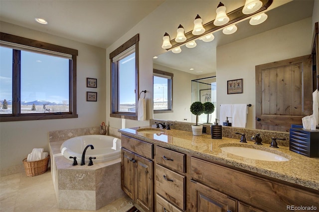 bathroom with tiled bath, vanity, and tile patterned floors