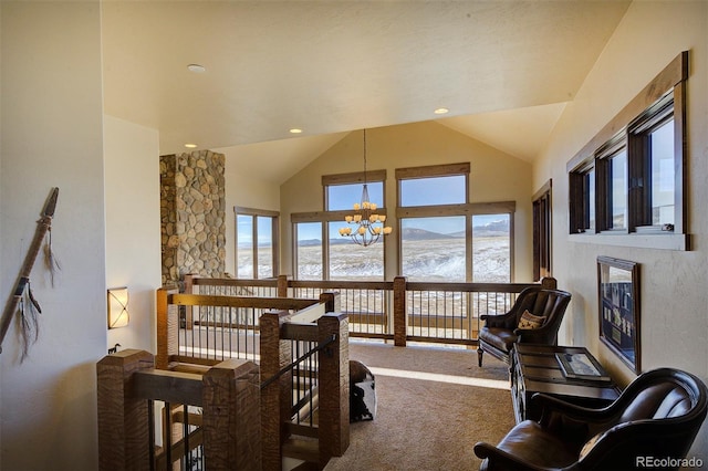 living room with lofted ceiling, carpet, an inviting chandelier, and a mountain view