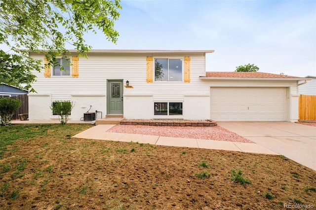 2988 S Hannibal St, Aurora, CO 80013 - view of front of house featuring an attached garage, cooling unit, concrete driveway, and brick siding