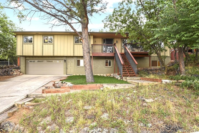 view of front facade featuring brick siding, driveway, an attached garage, and stairs