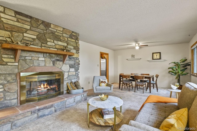 carpeted living room featuring ceiling fan, a fireplace, and a textured ceiling