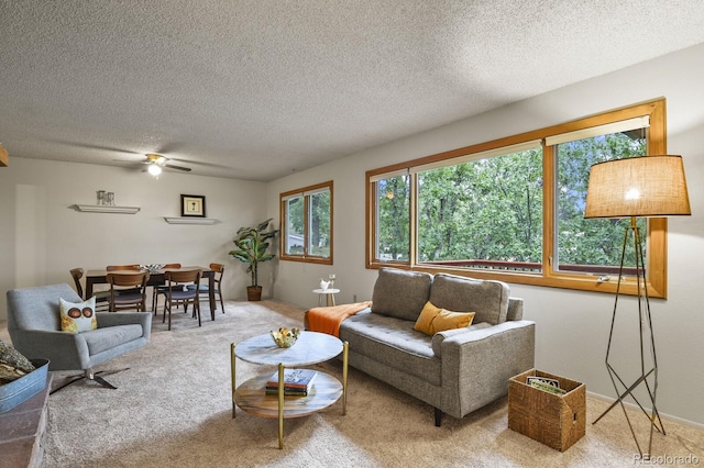 living area featuring a textured ceiling, ceiling fan, and carpet floors