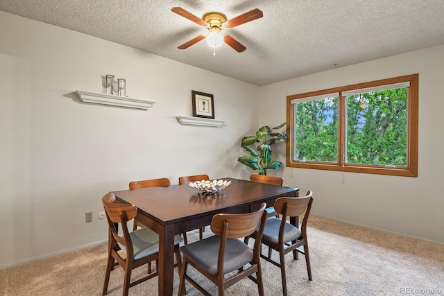 dining area with a textured ceiling, ceiling fan, and light carpet