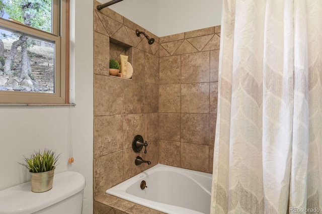 bathroom featuring toilet and tiled shower / bath combo