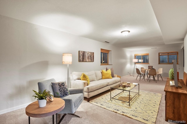 living area with visible vents, baseboards, and carpet