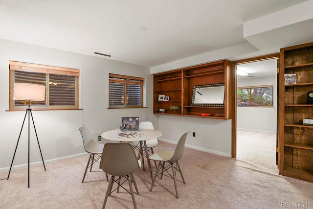 dining space with light colored carpet and baseboards