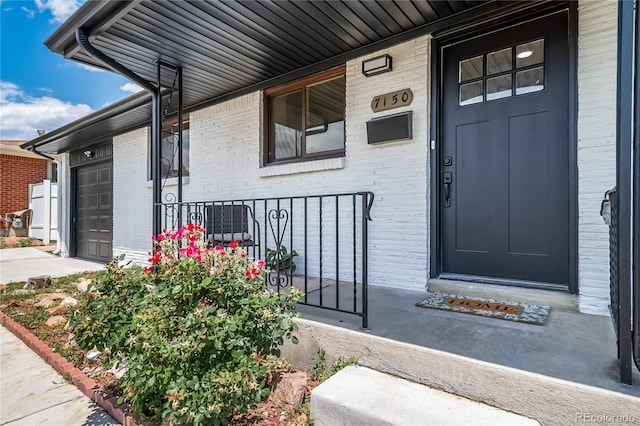 7150 Beach St, Westminster, CO 80030 - property entrance with a porch, brick siding, and an attached garage