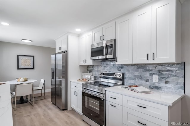 7150 Beach St, Westminster, CO 80030 - kitchen featuring stainless steel appliances, white cabinets, backsplash, light wood-type flooring, and recessed lighting