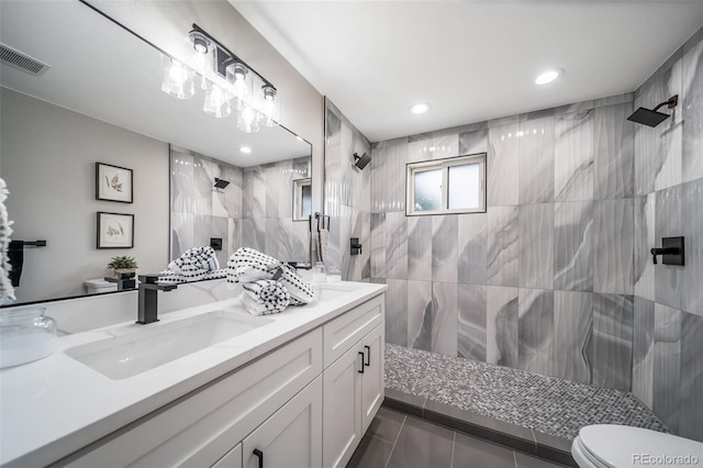 7150 Beach St, Westminster, CO 80030 - bathroom with double vanity, a tile shower, tile walls, tile patterned flooring, and recessed lighting