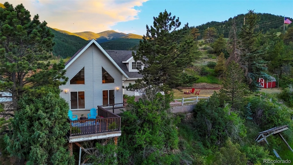 back house at dusk featuring a deck with mountain view