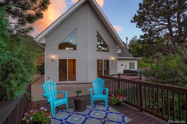 back house at dusk featuring a deck