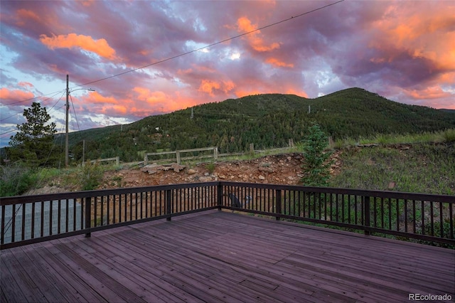 deck at dusk featuring a mountain view