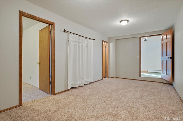 unfurnished bedroom with light colored carpet and baseboard heating