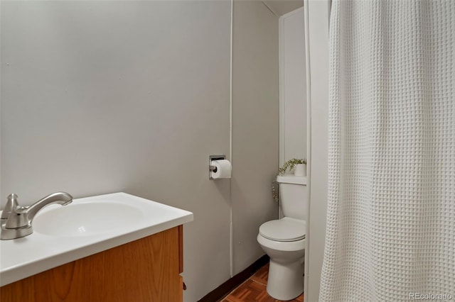 bathroom with vanity, parquet flooring, and toilet