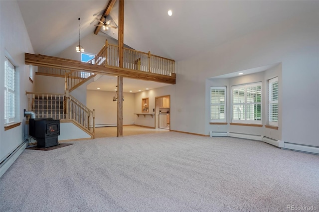 unfurnished living room with high vaulted ceiling, a wood stove, carpet floors, beamed ceiling, and ceiling fan