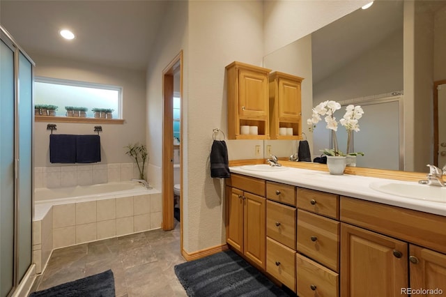 bathroom with vanity, tile patterned flooring, a relaxing tiled tub, and toilet