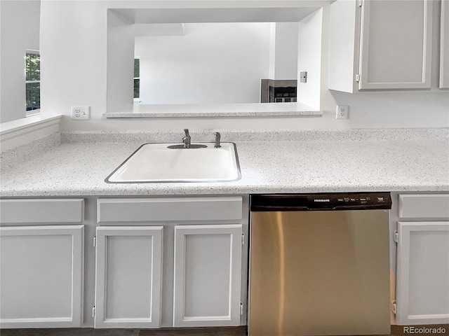 kitchen featuring dishwasher, a sink, and light countertops