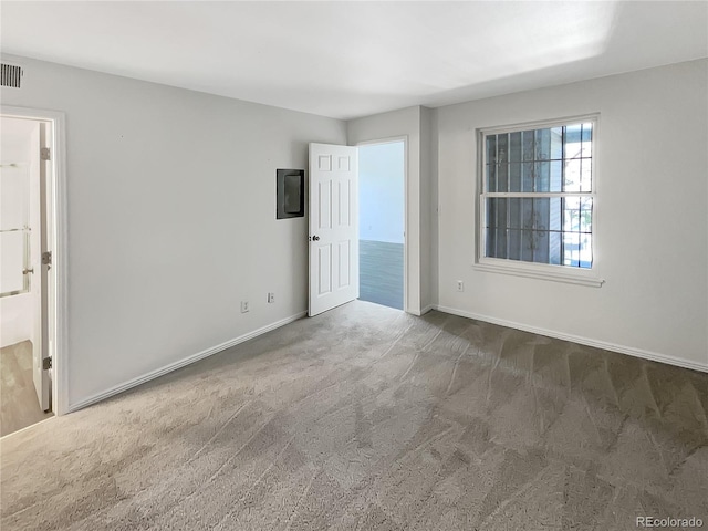 spare room featuring carpet flooring and baseboards