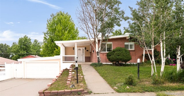 6535 Balsam St, Arvada, CO 80004 - view of front of property featuring brick siding, a garage, driveway, and covered porch