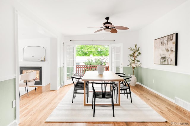6535 Balsam St, Arvada, CO 80004 - dining area featuring ceiling fan, light wood-style floors, a glass covered fireplace, and baseboards